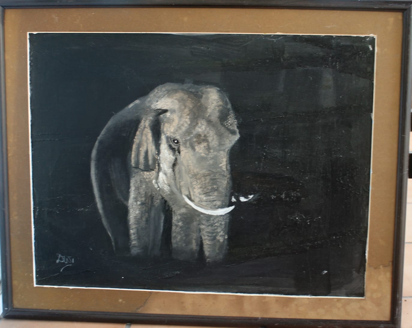 Painting of a grey tusked elephant emerging from a black background, shown in a brown mount and dark frame